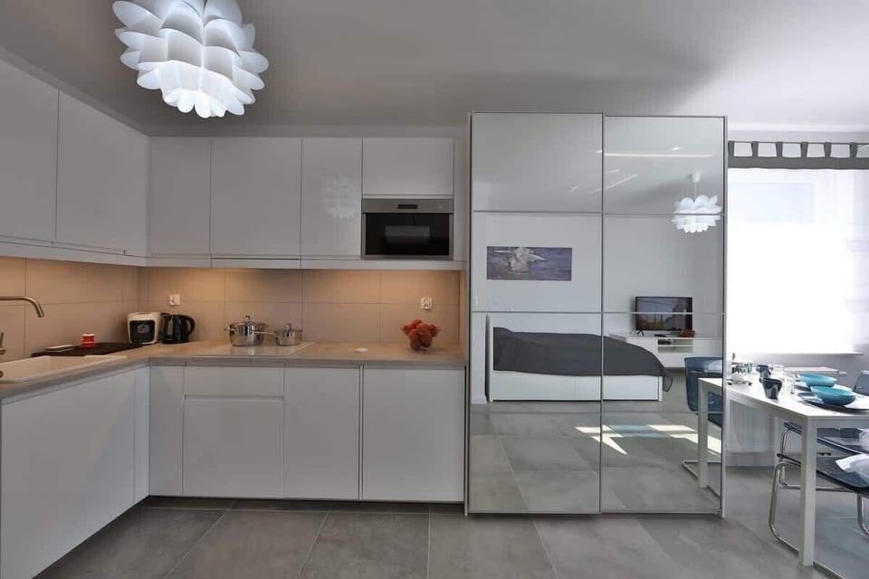 A modern kitchenette equipped with corner cabinets, offering plenty of storage and counter space.