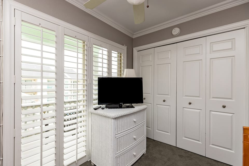 Relax in your bright bedroom with plantation shutters, flat-screen TV, and generous storage space for all your vacation essentials.