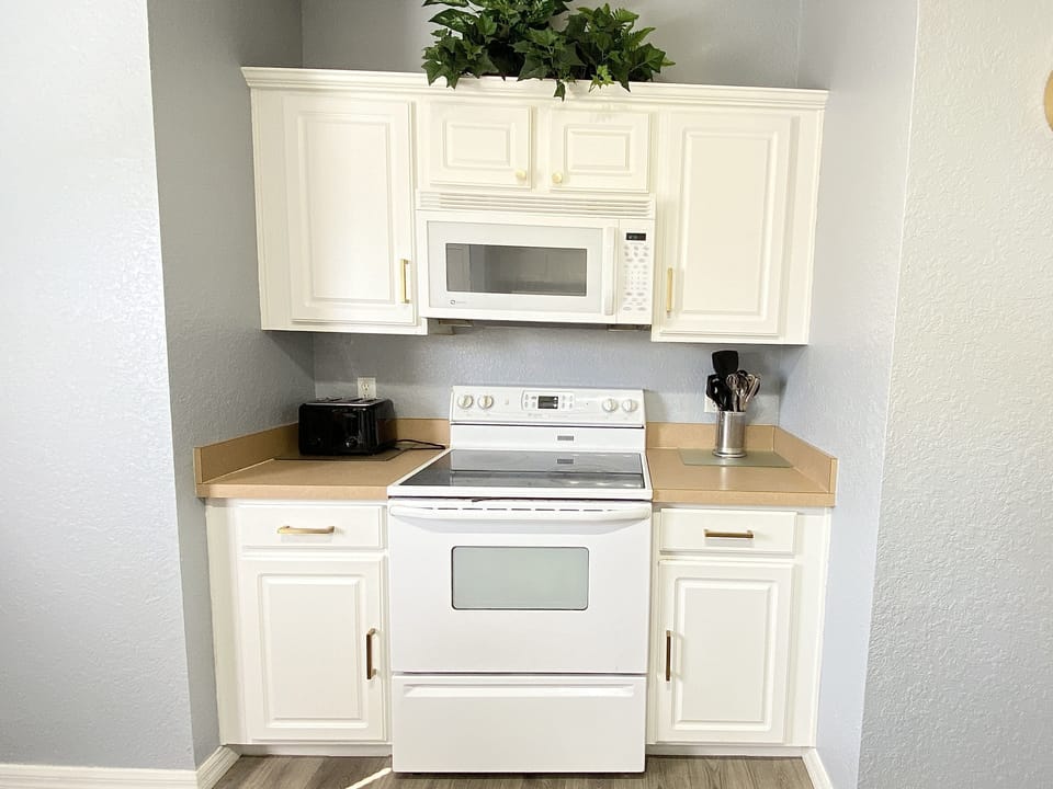 Fully equipped kitchen featuring modern appliances, including a stove and microwave.