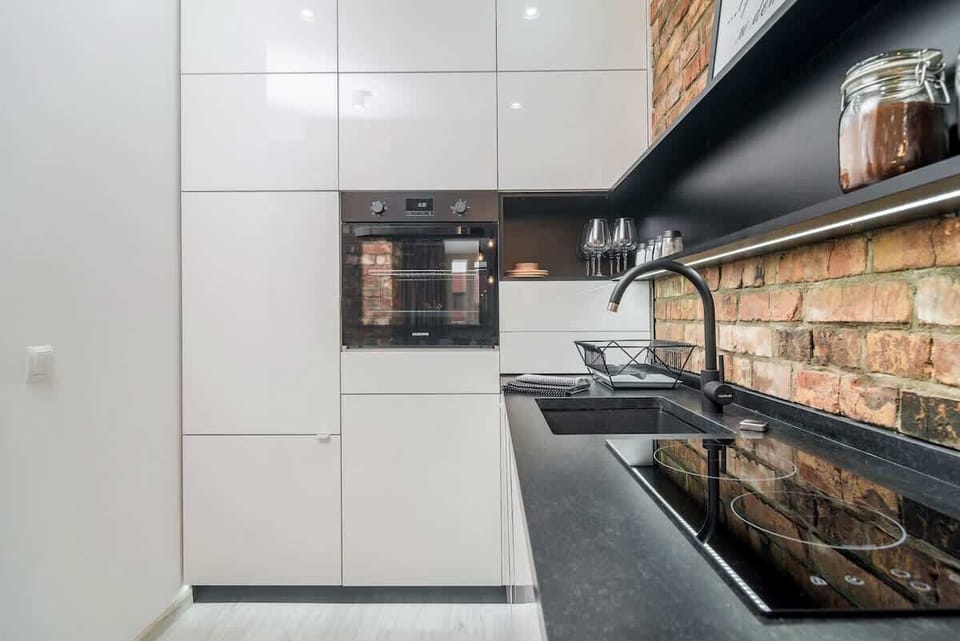 Kitchenette with dishwasher, kettle, stove, sink, oven and cupboards