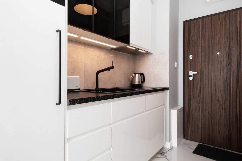 Another view of the kitchen, showcasing a modern stovetop, coffee machine, and organized cabinetry.