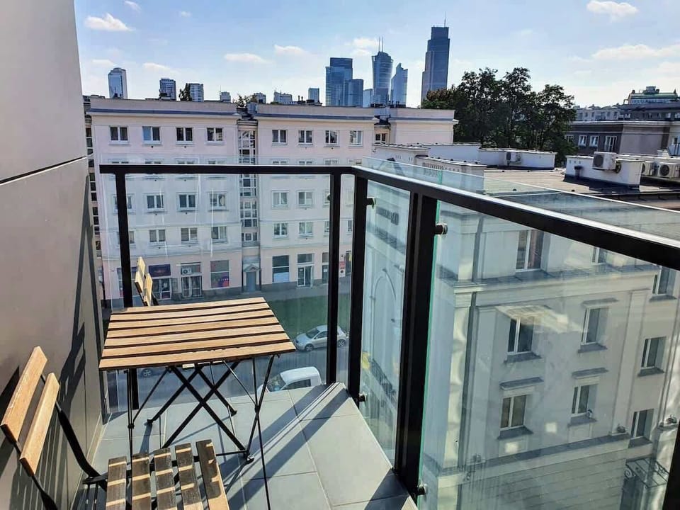 Another balcony perspective with a clear view of the city rooftops and open skies.