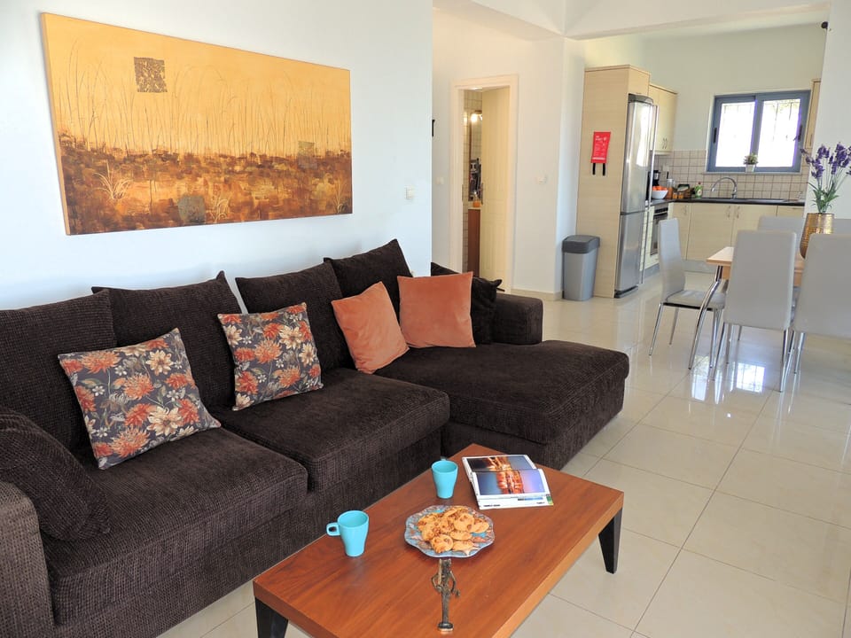 13 Amira open plan living room and kitchen with door to half bathroom.