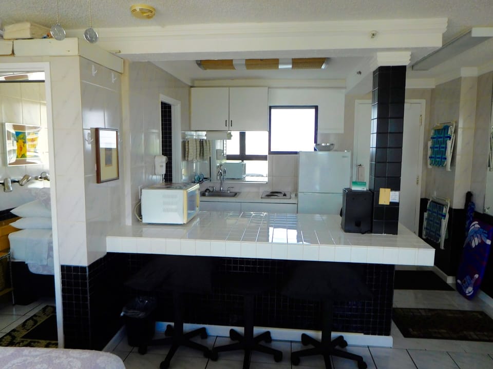 Kitchen View.  Closet on the left.  Stools at the food bar.