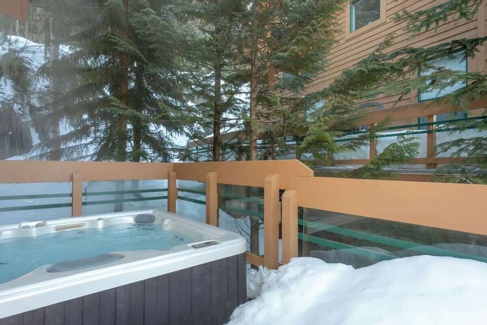 - Private outdoor hot tub surrounded by snow and pine trees  
- Steam rises as you unwind under crisp mountain skies  
- The perfect après-ski soak in your own secluded haven 