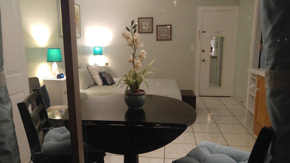 View into apartment from lanai. Dining table, queen sized bed