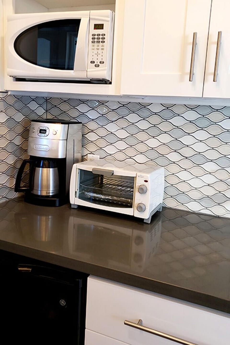 Fully stocked kitchenette with microwave, Keurig, toaster oven & refrigerator.
