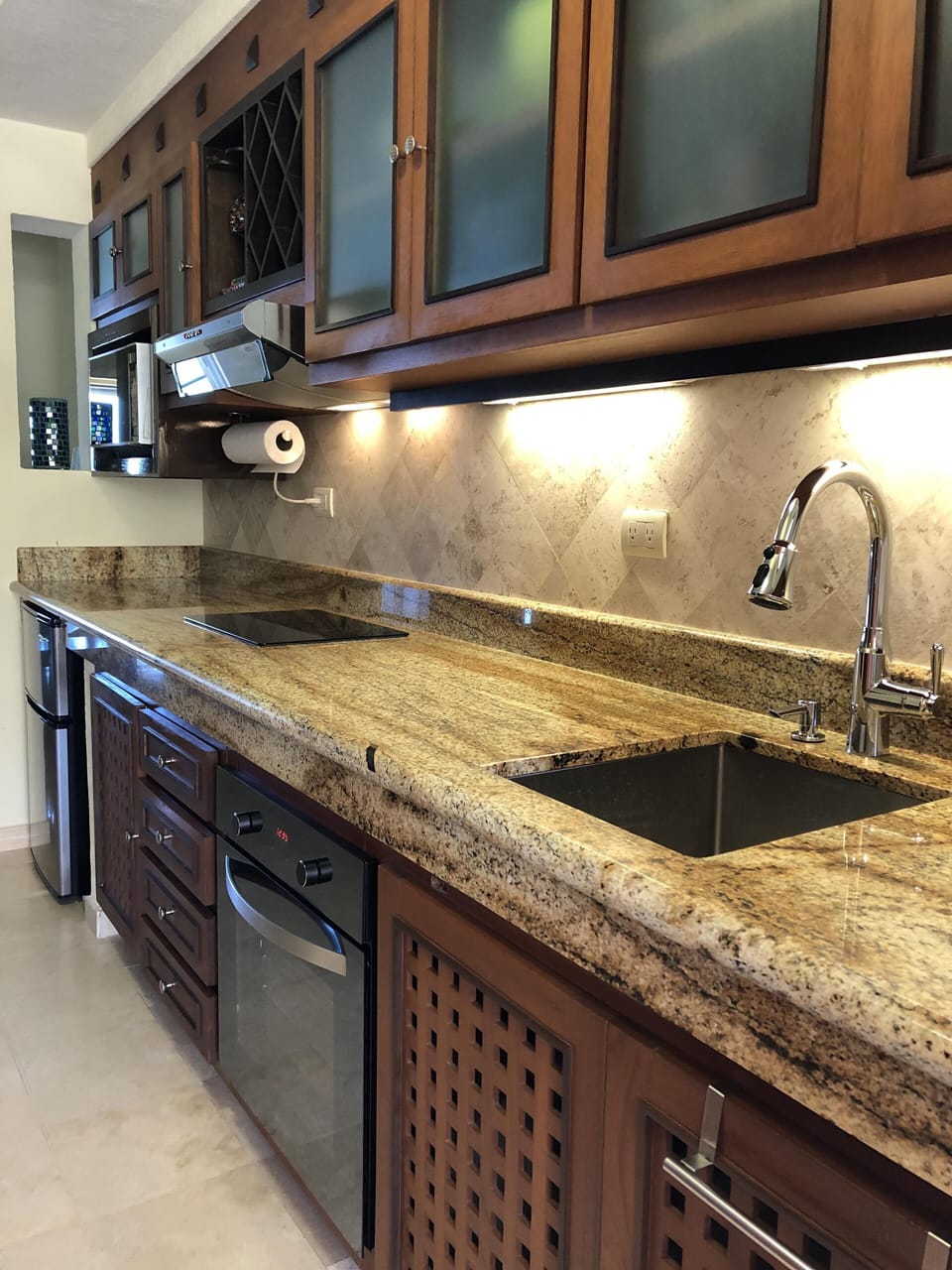 Newly renovated kitchen with induction cooktop, two mini fridges, and oven. 