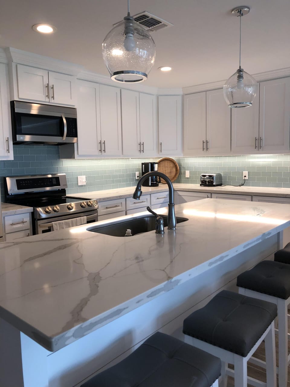 Beautiful quartz countertops and glass backsplash.