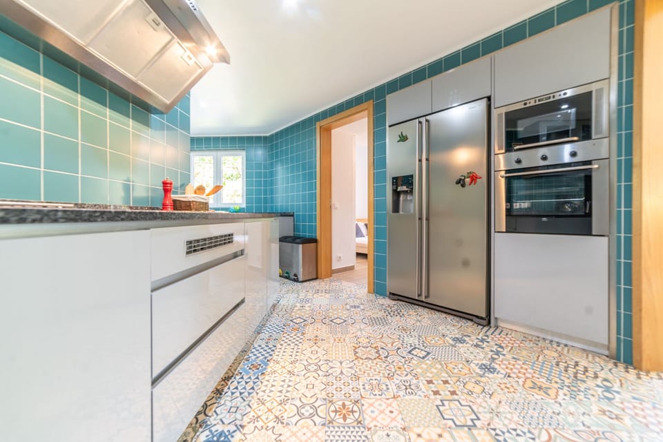 Modern turquoise-tiled kitchen with stainless steel appliances — Villa das Begonias, holiday villa in Herdade de Aroeira