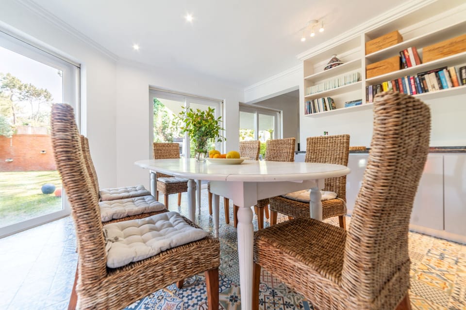 Bright dining room with woven chairs and built-in shelving — Villa das Begonias, luxury holiday villa in Herdade de Aroeira