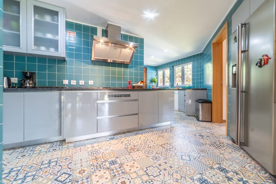 Modern kitchen with turquoise tile walls and patterned floor — Villa das Begonias, holiday villa in Herdade de Aroeira