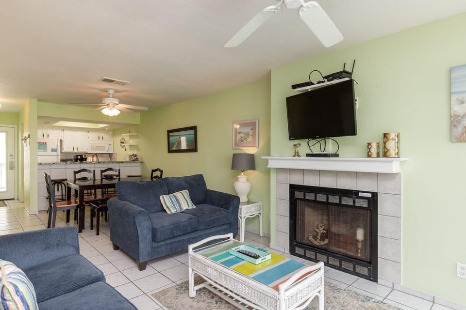 Unwind in your cozy living space with comfortable seating, warm fireplace, and entertainment center for perfect vacation evenings.