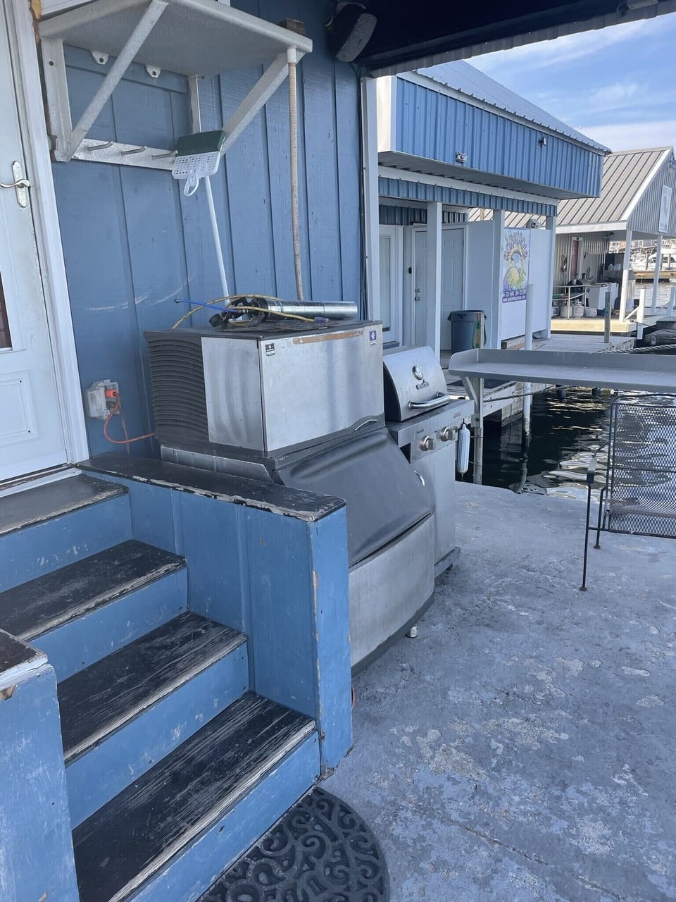Water front porch with ice machine, fish cleaning table, and propane grill