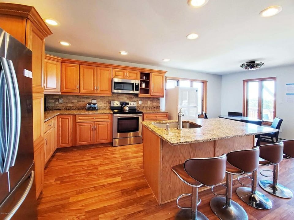 4 bar stools. Sliders walks out to BBQ grill, fire pit table, dining sets