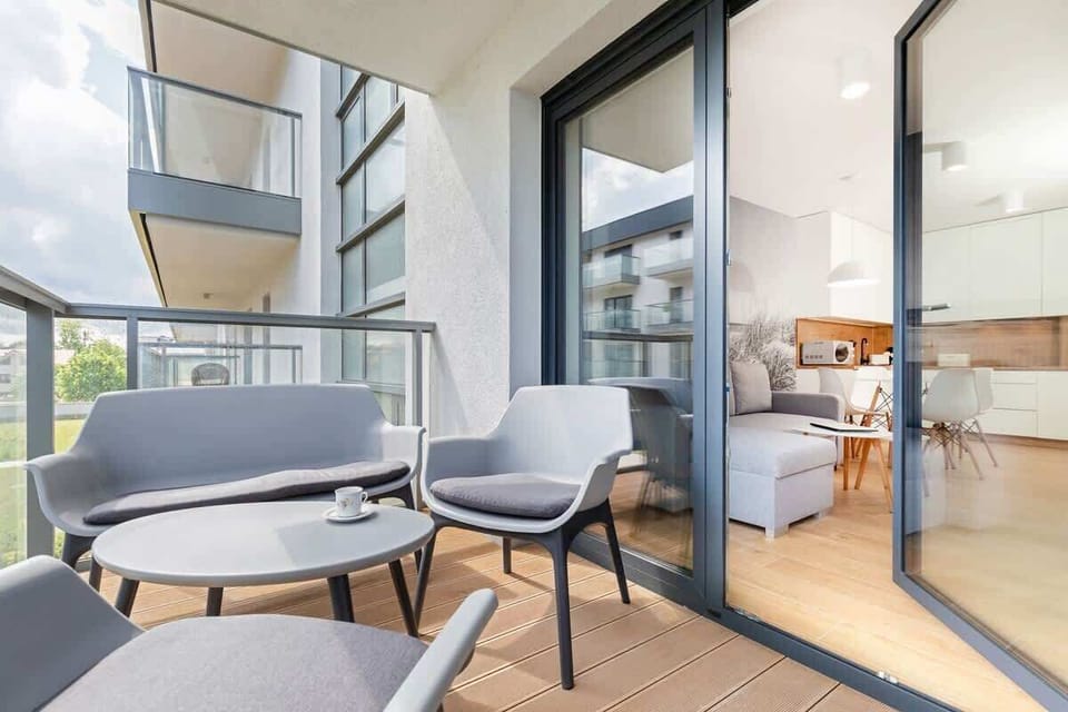 A close-up view of a balcony area, showing two stylish black chairs and a small side table, providing a spot for relaxation.