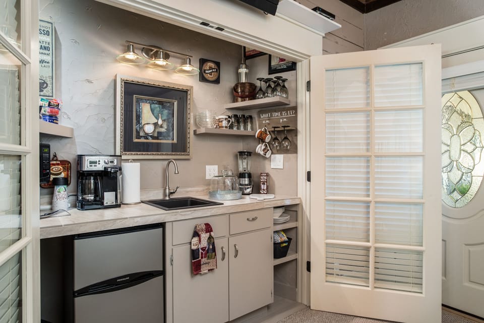 Coffee bar area W/frig, wine glasses, ice bucket, dishes, silverware, etc
