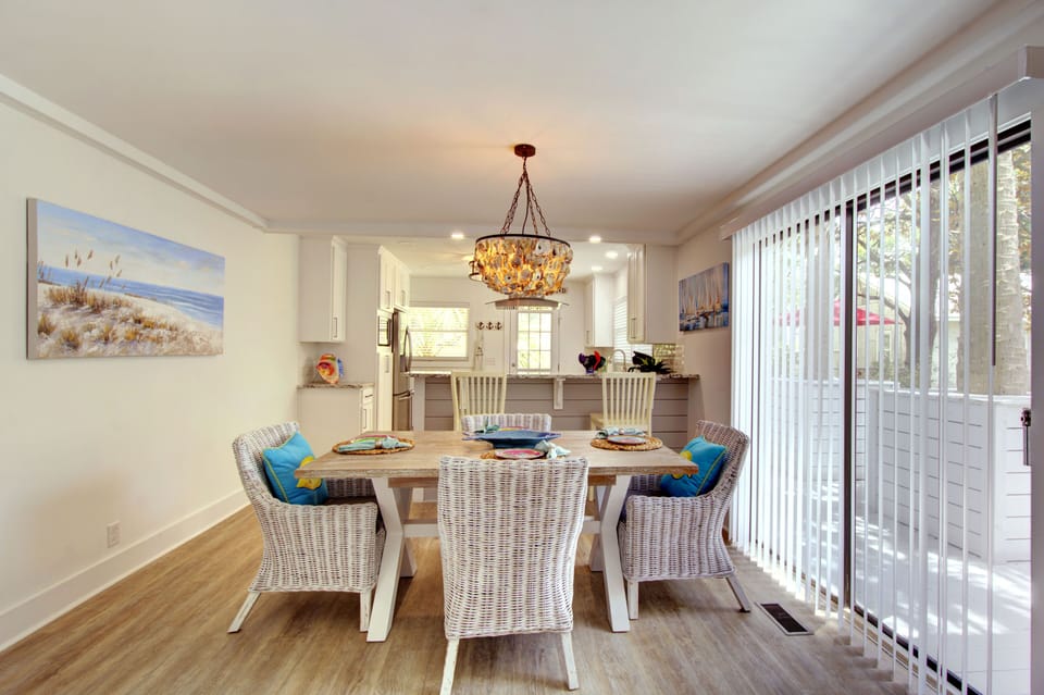 Dining Area With Patio Light - Seating for six sits beside the sliding glass doors, giving the dining area natural light and a direct view toward the patio.