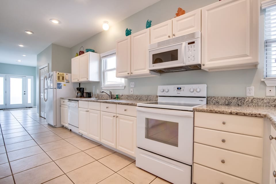 Kitchen - The spacious kitchen offers both small and large appliances. A built in microwave, dishwasher, oven with smooth cooktop and a refrigerator-freezer with ice maker is all included along with a coffee maker, blender, and toaster to name a few. The cabinetry is fully stocked with all of the items you will need for preparing your meals on site. Just bring the groceries!