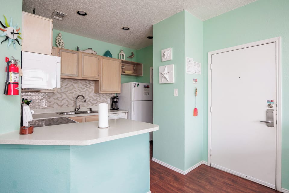 Unwind in your modern kitchen featuring mint walls, granite counters, and everything you need to whip up delicious vacation meals.