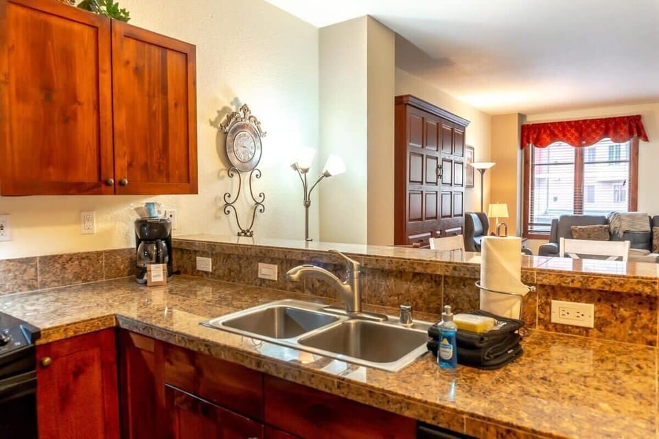 The view from the kitchen shows its close proximity to the dining and living spaces. The kitchen bar seats two and makes for easy serving to the nearby dining table.