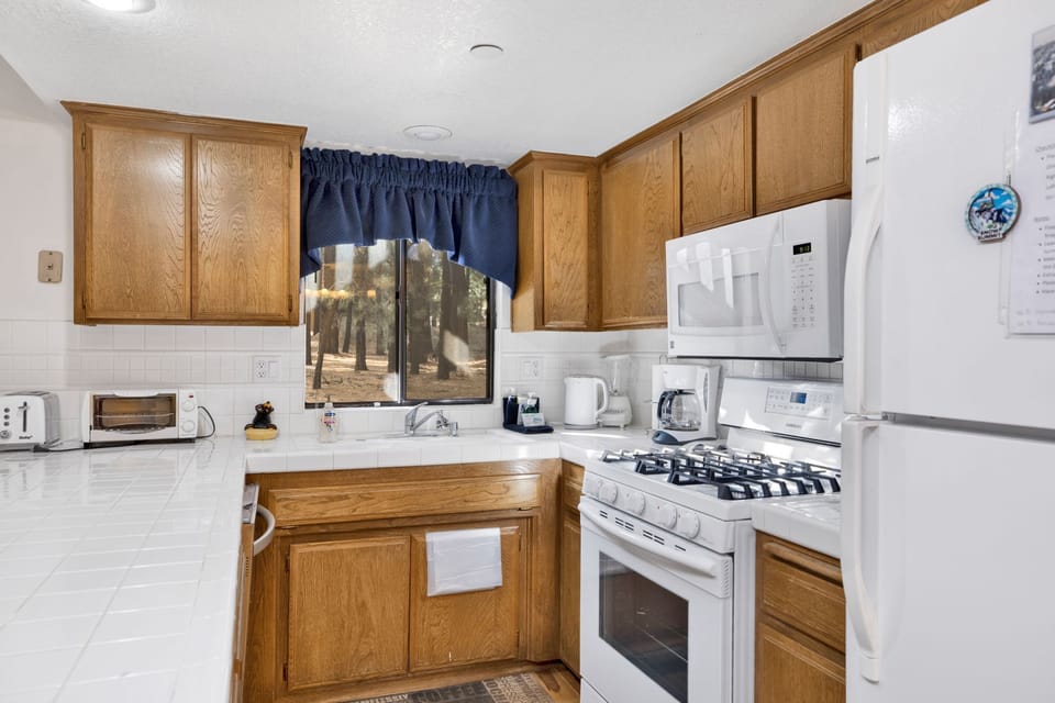 Fully equipped cabin kitchen with ample cabinetry, stove, fridge, microwave, and coffee maker—perfect for cooking meals, morning coffee, and feeling right at home on your stay.