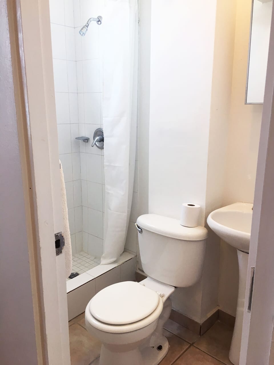Vista al baño. El mismo cuenta con ducha, toilette y lavamanos.