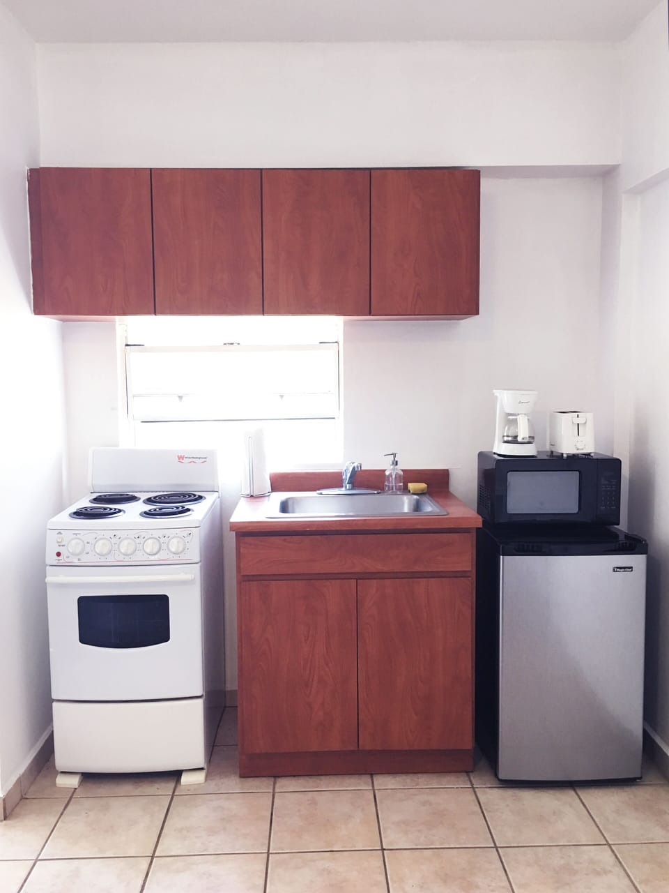 Cocina equipada con los utensilios básicos, tostadora, estufa, cafetera y otros.