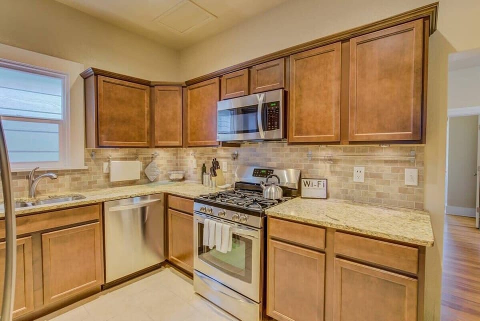 Classic kitchen with wood cabinetry, tiled counters, and a full stove—set out snacks, brew something warm, and cook at your own pace with everything within reach.