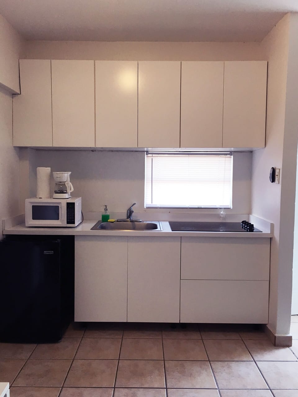 Cocina equipada con los utensilios básicos, tostadora, estufa, cafetera y otros.
