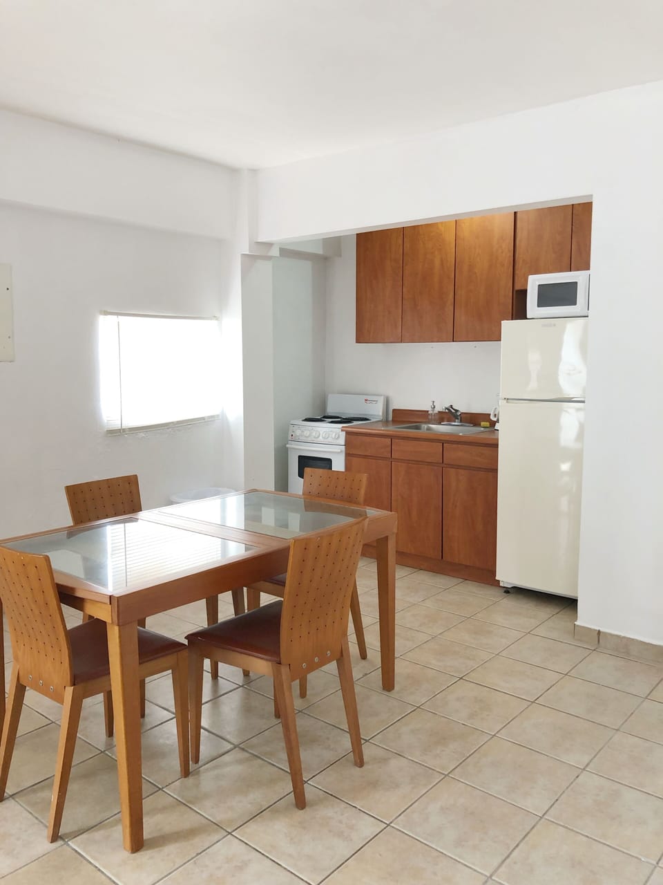 Area de comedor con 4 sillas, smart TV y esta proximo al area de cocina.