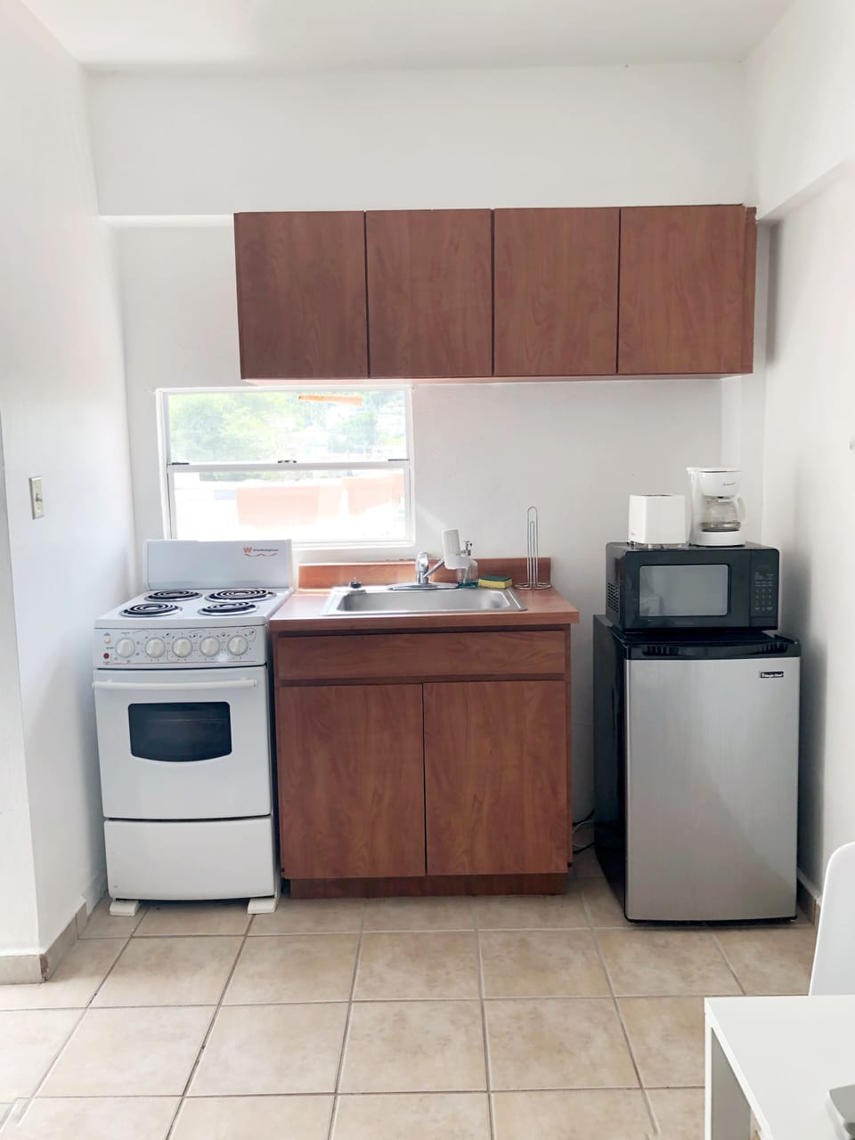 Cocina equipada con los utensilios básicos, tostadora, estufa, cafetera y otros.