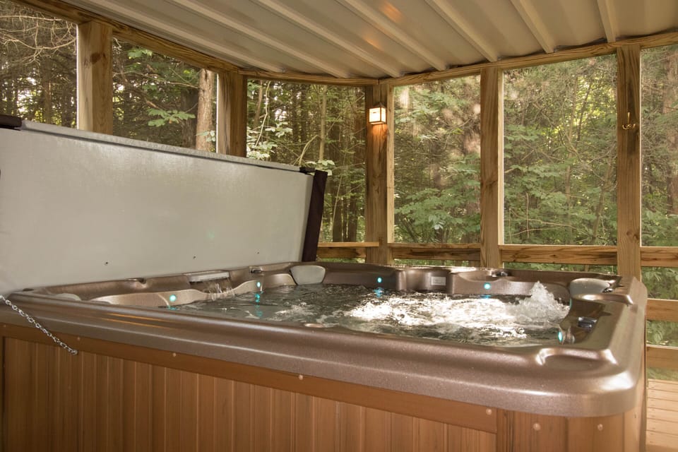 Relaxing hot tub in a beautiful setting in a screened in porch.