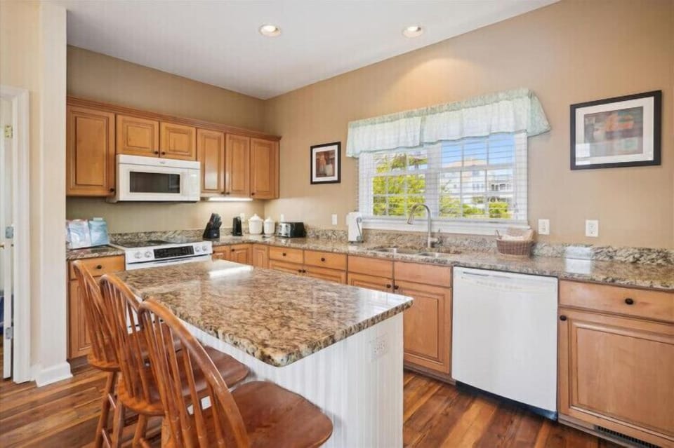 Your fully-equipped kitchen invites you to whip up home-cooked meals with modern appliances, granite countertops, and a center island with seating for casual dining.