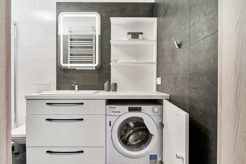 Bathroom of Świstackiego 19/10 with shower, sink, toilet, mirror and washing machine