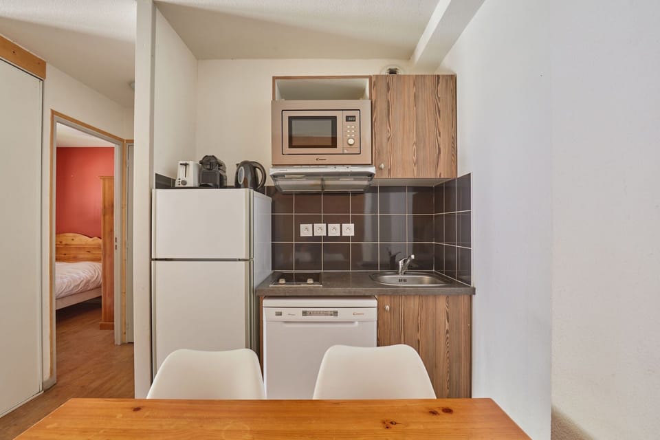Kitchenette with a refrigerator and a microwave above