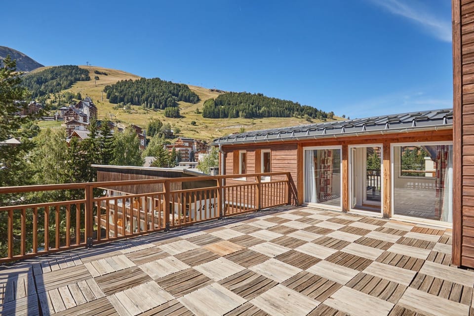 Balcony overlooking green hills and nearby buildings