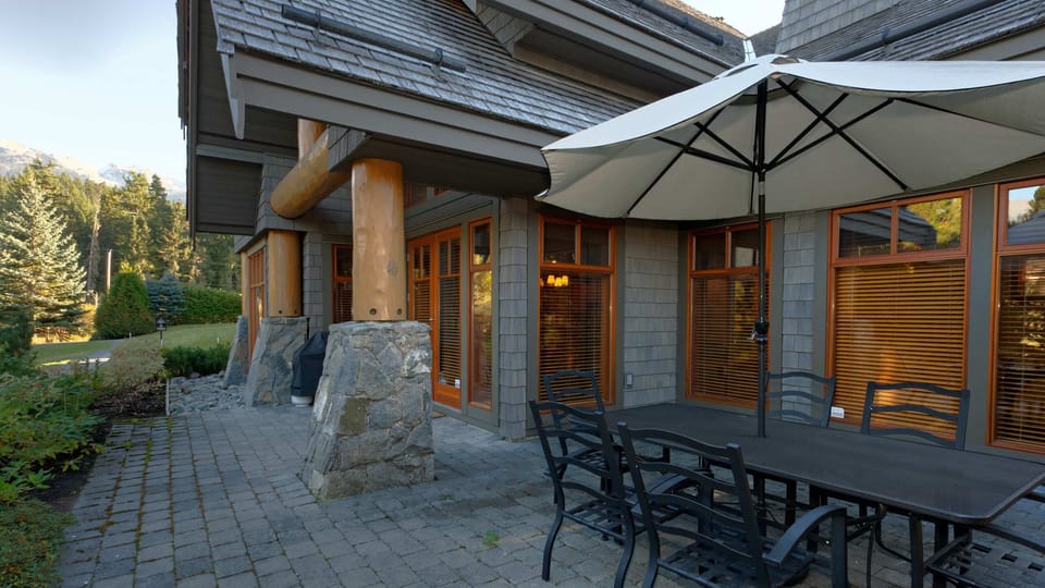 - Outdoor patio with dining setup under large umbrella  
- Surrounded by greenery and stone architecture  
- Perfect for fresh air breakfasts or sunset dinners  
