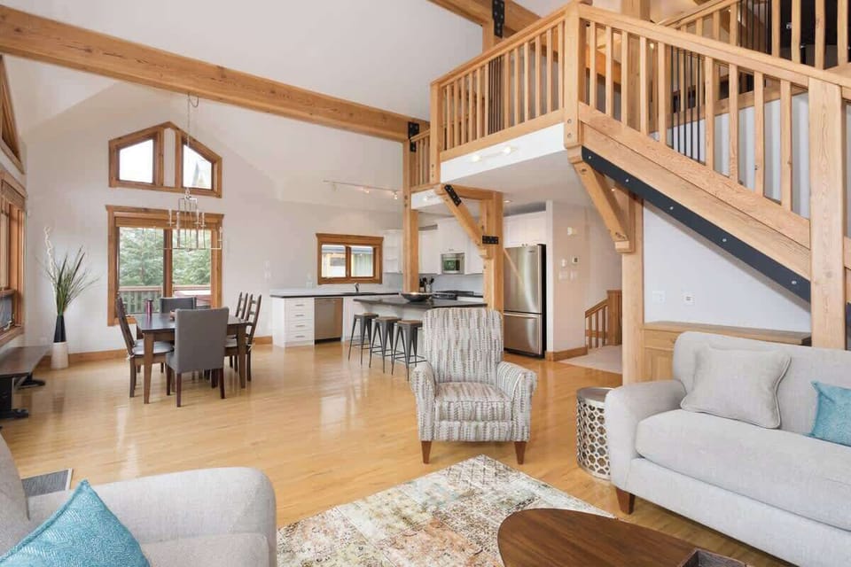 - Elegant dining area with tall windows showcasing pine forest views  
- Wooden table and modern chandelier set a welcoming tone  
- Perfect for shared meals in a bright mountain atmosphere  
