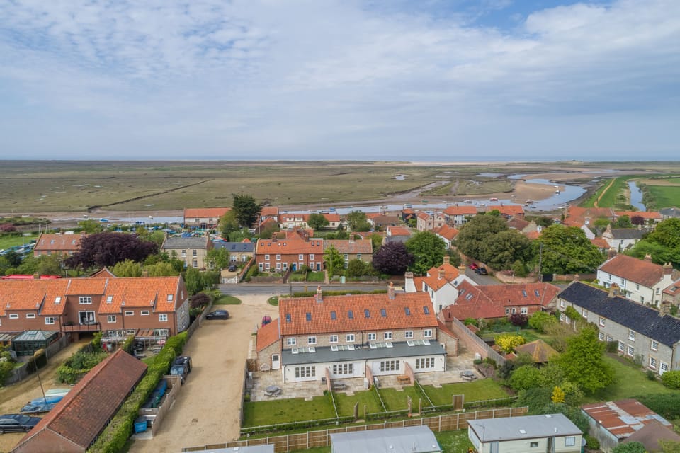 Aerial view of Burnham Overy Staithe and The Hero cottages in the foreground