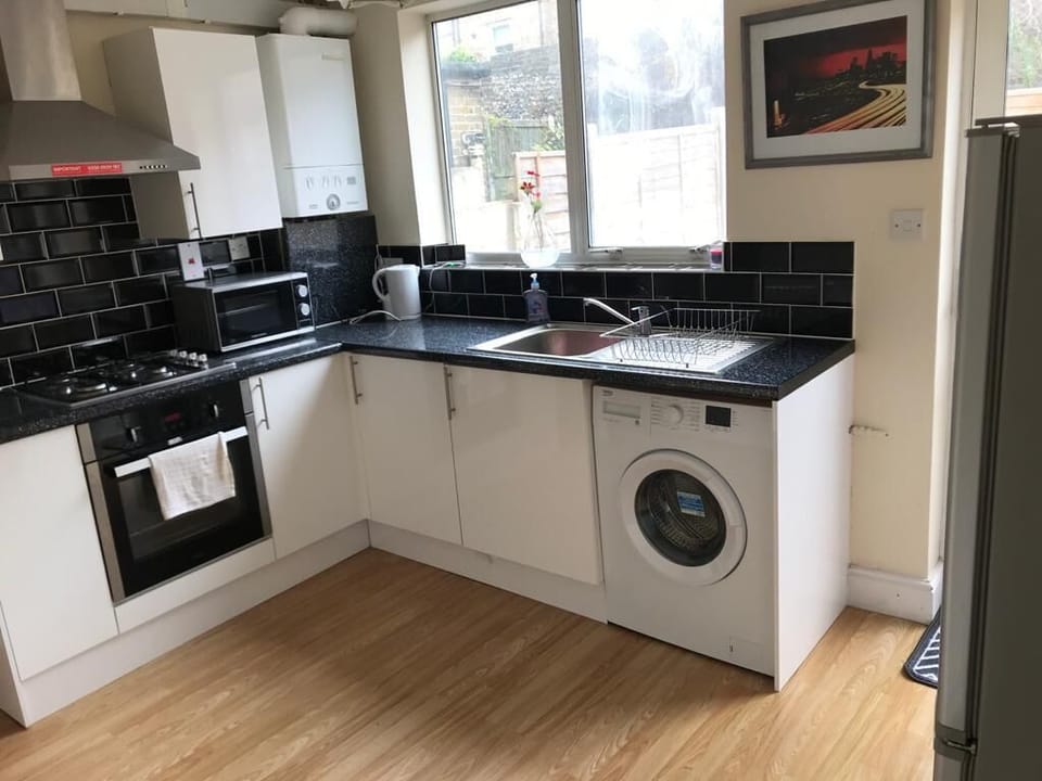 Kitchen with cooker, oven, microwave, fridge, kettle, toaster.
