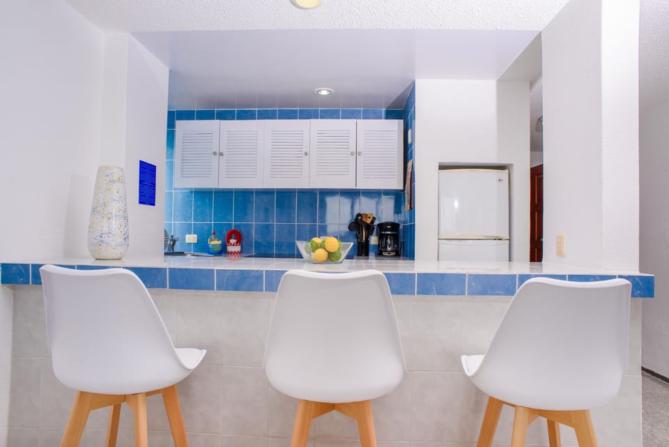 Cute kitchen includes pots, pans, utensils, blender, coffee, dishes, fridge 