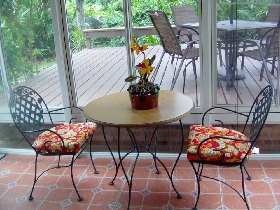 Glass-and-screen lanai makes a cheerful breakfast spot for two... or more