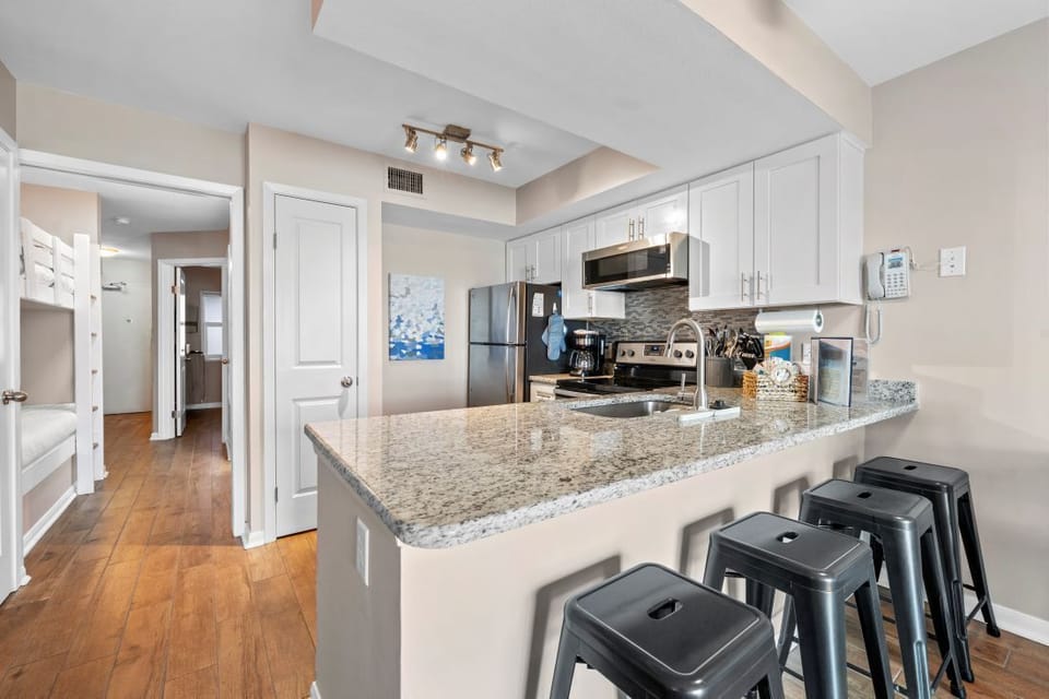 Your fully equipped kitchen features granite countertops, stainless steel appliances, and a breakfast bar where you can enjoy morning coffee or casual meals.