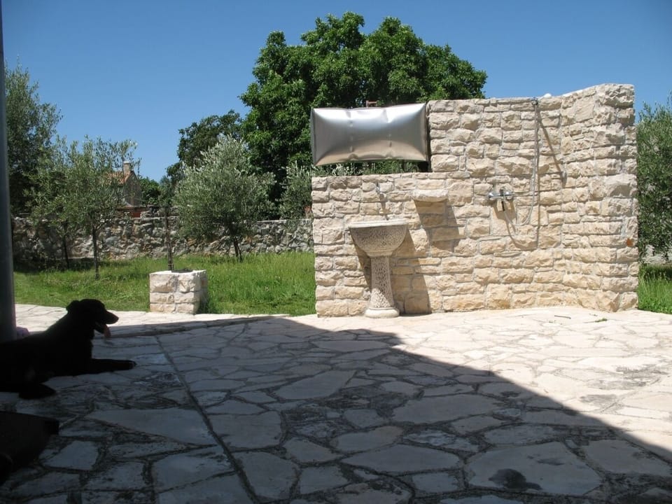 External stone shower and olive garden