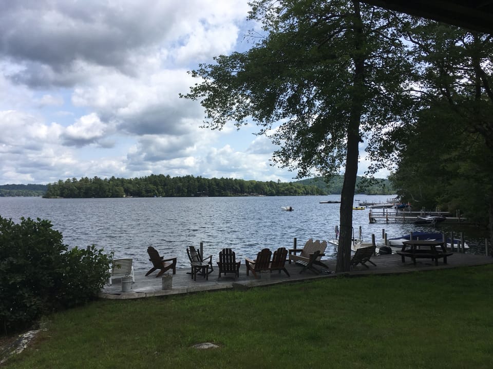 Lawn and deck on the water with Adirondack chairs
