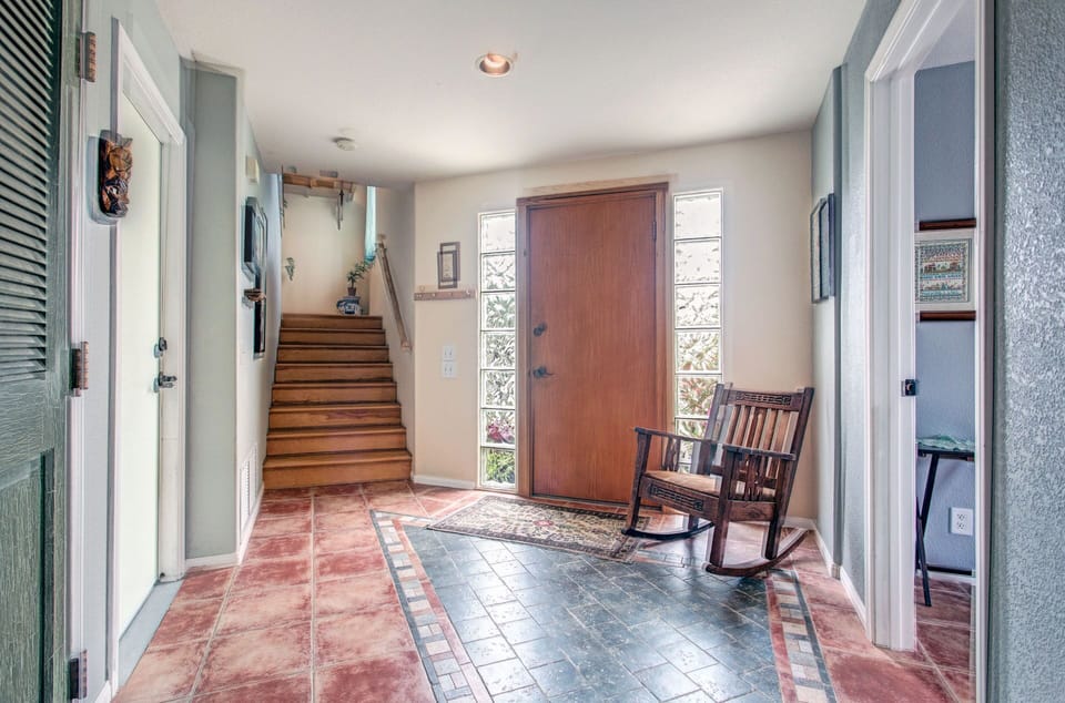 Enter the home into this large open space area with a rocking chair.