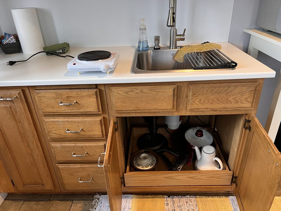 A countertop 1 burner stove and some pans allow for simple meals.