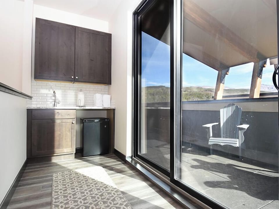 Your sleek kitchen opens to a private deck with mountain views, perfect for morning coffee or evening meals overlooking the peaceful landscape.