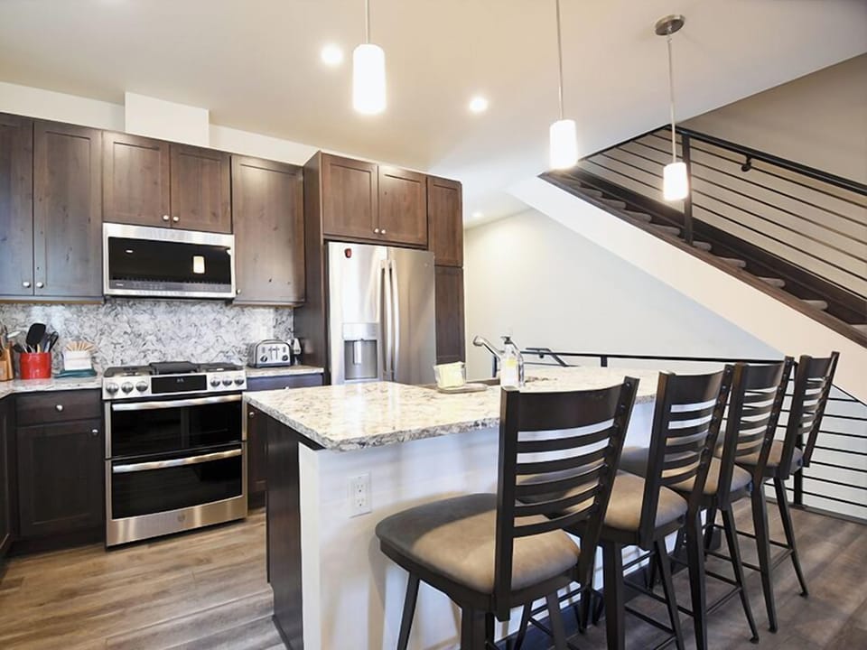 Your stylish kitchen features granite countertops, stainless appliances, and cozy island seating perfect for morning coffee or evening conversations.